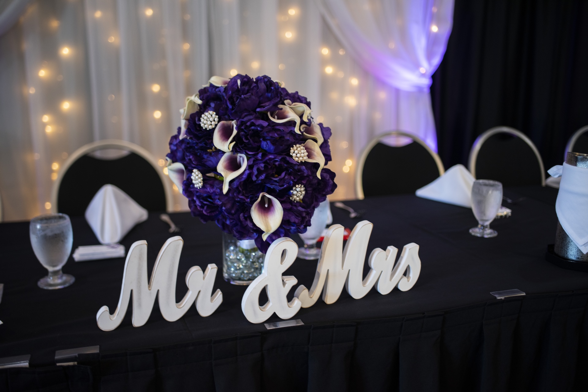 The Pavilion wedding head table with a vase of flowers with a Mister and Misses sign in front