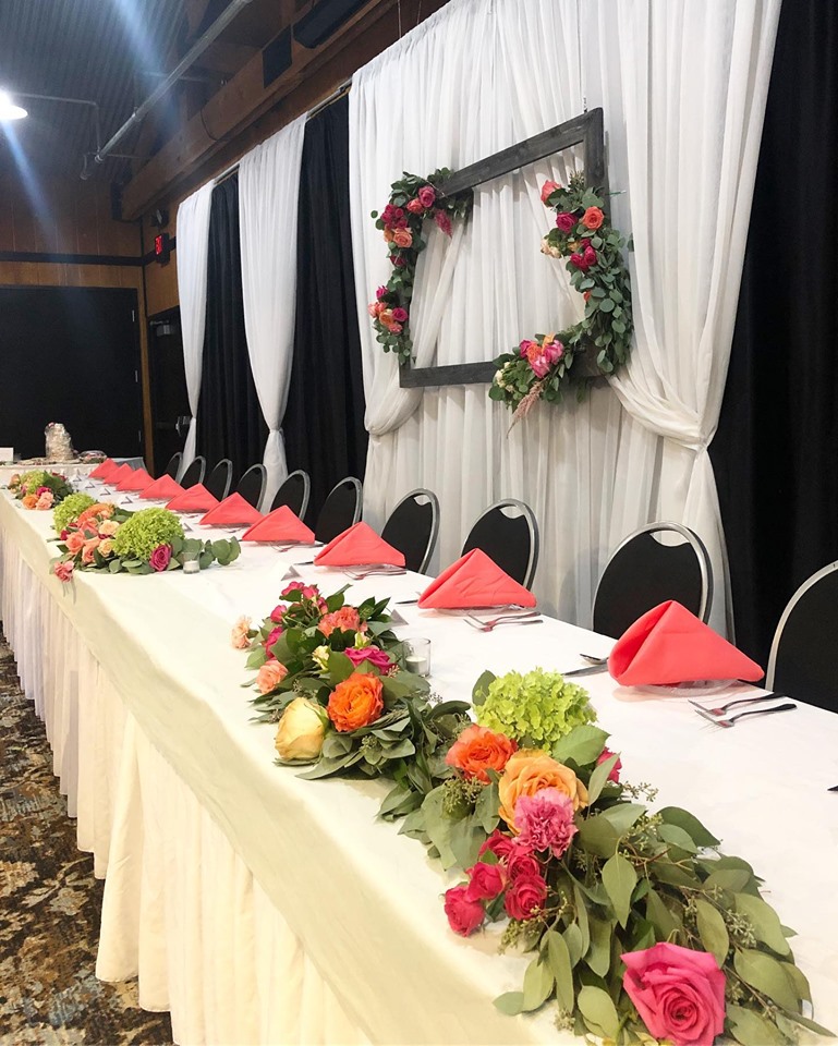 Head table decorated with flowers and set up with plates for food